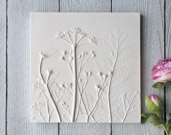 May include: White plaster wall art featuring a raised relief design of pressed wildflowers and ferns.