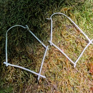 May include: Two silver hoop earrings with a unique, geometric design. The earrings are made of thin, silver wire and have a simple, modern look.