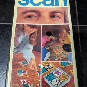 May include: A vintage board game box for "Scan", a split-second matching game by Parker Brothers. The box features a photo of people playing the game and the game's title in blue and white letters.