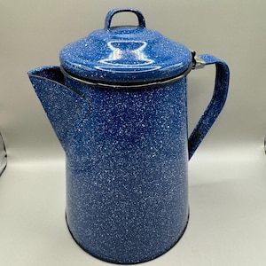 May include: Blue enamel coffee pot with white speckles. The pot has a lid and a handle.