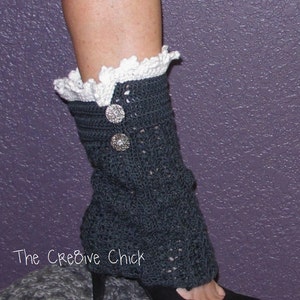 Puede incluir: Calentadores de piernas de crochet con un borde de encaje blanco y botones plateados. Los calentadores de piernas son de color gris oscuro y se usan con tacones negros. El texto "The Creative Chick" es visible en la imagen.