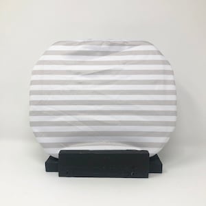 以下が含まれることがあります： 黒色の木製の台座に置かれた、グレーと白のストライプ模様の丸いクッション