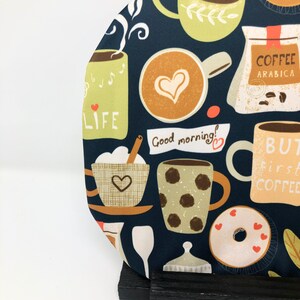 Könnte beinhalten: Ein dunkelblauer Stoff mit einem sich wiederholenden Muster aus Kaffeetassen, Bechern, Donuts und Kaffeebohnen. Der Stoff hat einen weißen Hintergrund mit einem grünen und braunen Muster. Der Text "Good morning!" ist in Orange und Rot auf weißem Hintergrund geschrieben. Der Text "But first, coffee" ist in Orange und Rot auf weißem Hintergrund geschrieben. Der Text "Life" ist in Orange und Rot auf weißem Hintergrund geschrieben. Der Text "Coffee Arabica" ist in Rot auf weißem Hintergrund geschrieben.