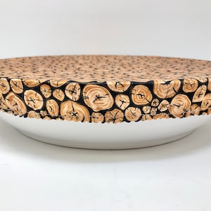 以下が含まれることがあります： 木目模様の黒とベージュの布製の丸いフードカバー。カバーは白いボウルにかけられています。