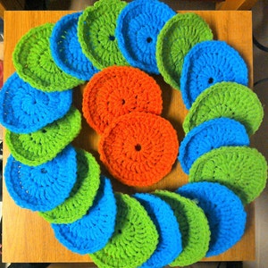 May include: A collection of crocheted circles in various shades of green, blue, and orange. The circles are arranged in a circular pattern, creating a visually appealing design.