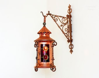 Kupferne Kerzenlaterne mit verzierter Wandhalterung. Französischer Vintage-Leuchter mit rotem Glas