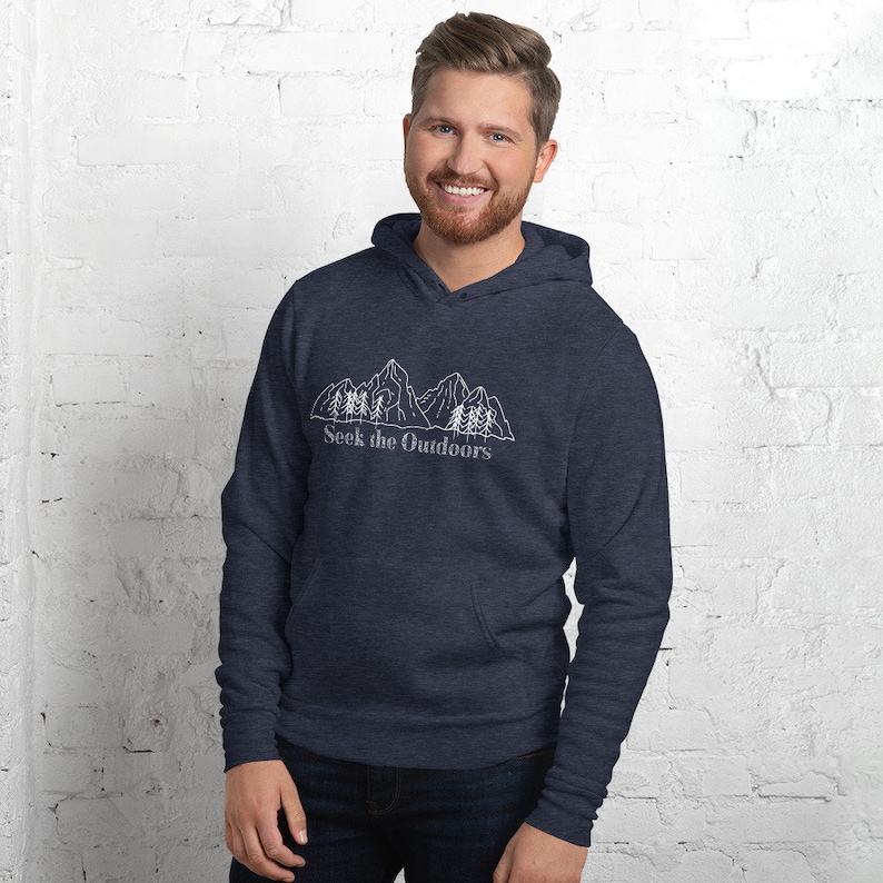 May include: A navy blue hooded sweatshirt with a white outline of mountains and trees. The text "Seek the Outdoors" is printed below the image.