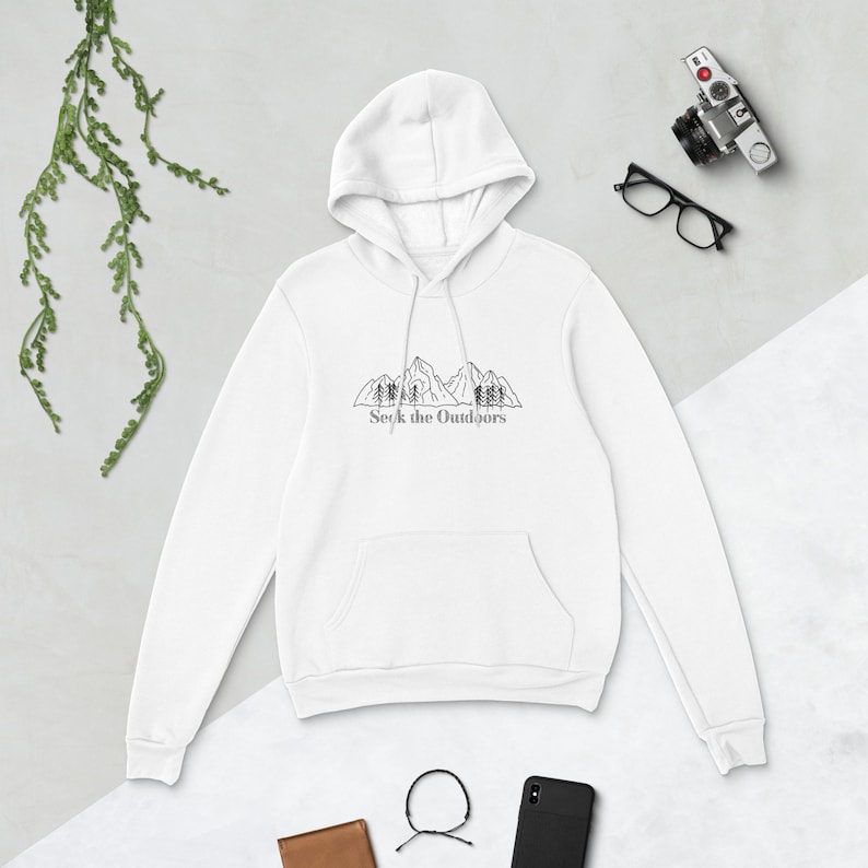 May include: White hooded sweatshirt with a black mountain range and trees graphic and the text "Seek the Outdoors" printed on the front.