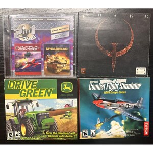 May include: Four PC game boxes arranged in a square. Top left is a 2-in-1 pack with Ultra Fighters and Spearhead. Top right is Quake. Bottom left is John Deere Drive Green featuring a green tractor. Bottom right is Microsoft Combat Flight Simulator.