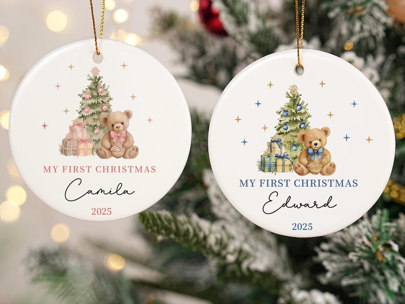 May include: Two white, round Christmas ornaments with gold string. Each features a teddy bear, Christmas tree, and gifts. One says "My First Christmas Camila 2025" and the other says "My First Christmas Edward 2025".