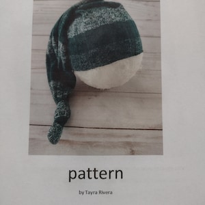 May include: A green and white striped sleeping hat pattern. The pattern is called "Sleepy hat" and is by Tayra Rivera.