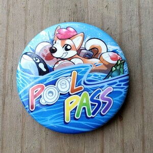 May include: A blue and white button with a cartoon dog wearing a life preserver and the text "Pool Pass" in rainbow colors.