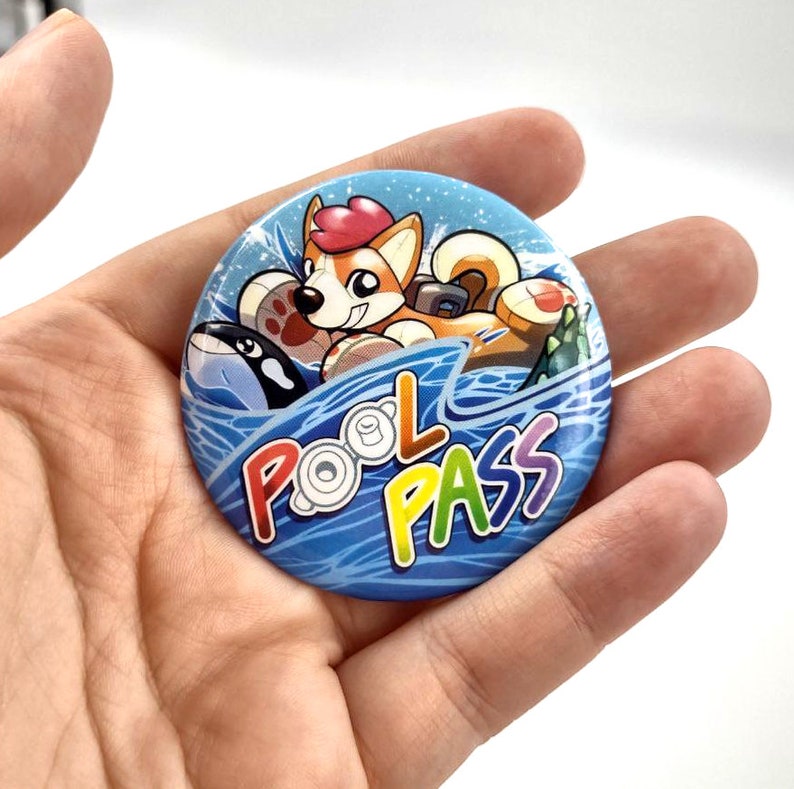 May include: A blue and white button with a cartoon dog wearing a life preserver and riding a wave. The text "POOL PASS" is written in rainbow colors on the wave.