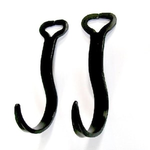 May include: Two black plastic hooks with a curved shape and a loop at the top.