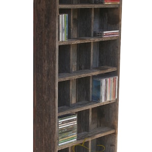 Puede incluir: Armario alto y r&uacute;stico de madera para guardar CD con m&uacute;ltiples compartimentos. El armario est&aacute; hecho de madera envejecida y lleno de CD. El texto "TEXAS CRAZY" es visible en la parte inferior del armario.