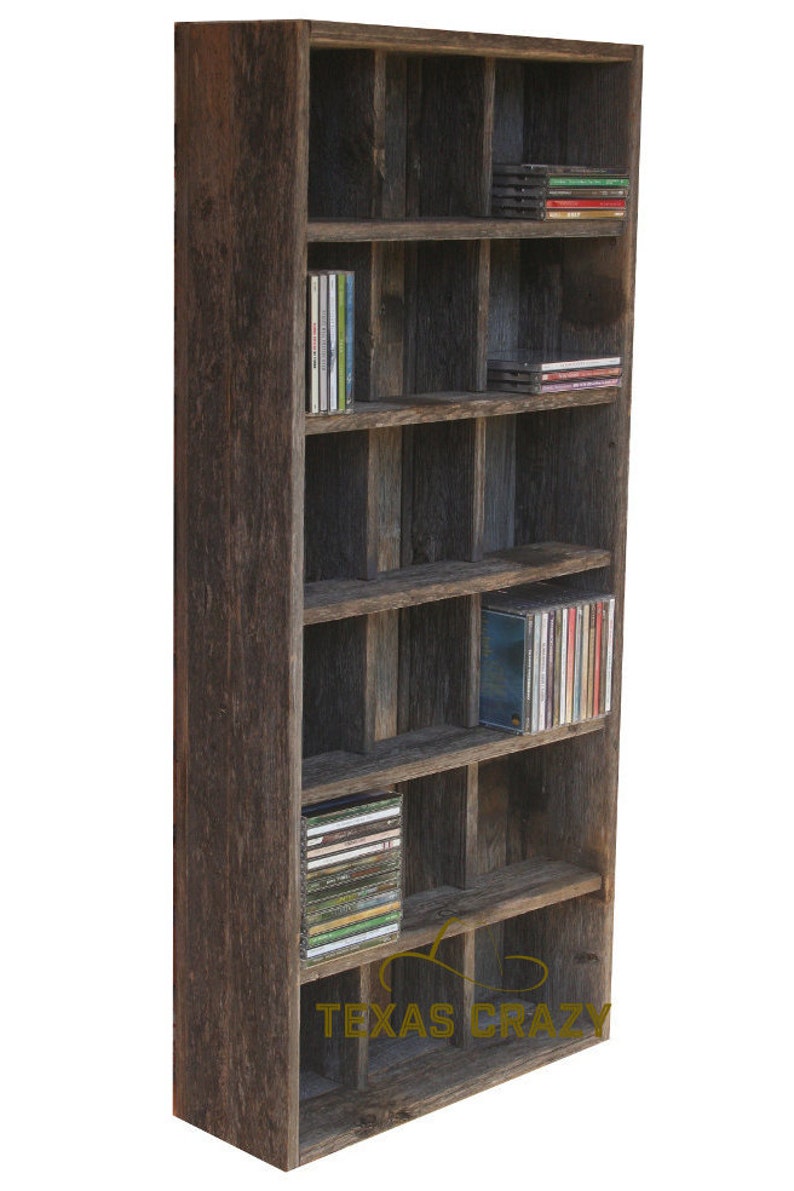 Puede incluir: Armario alto y r&uacute;stico de madera para guardar CD con m&uacute;ltiples compartimentos. El armario est&aacute; hecho de madera envejecida y lleno de CD. El texto "TEXAS CRAZY" es visible en la parte inferior del armario.