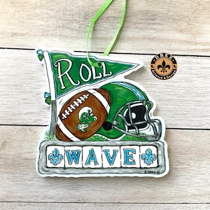 May include: Green and white football helmet with a brown football and a green and white flag that says "Roll Wave".