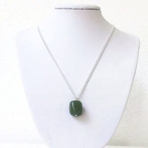 May include: A silver chain necklace with a dark green gemstone pendant.