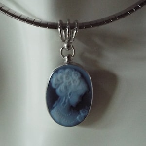 Portrait of a woman carved into a blue (black) agate cameo set in sterling silver pendant.