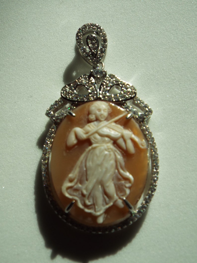 Master hand carved sardonyx cameo set into sterling silver pendant with cubic zirconia