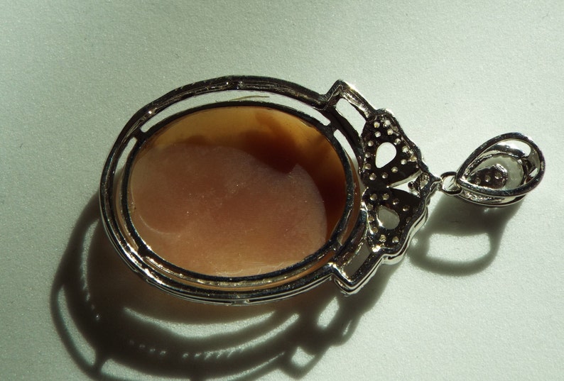 Master hand carved sardonyx cameo set into sterling silver pendant with cubic zirconia