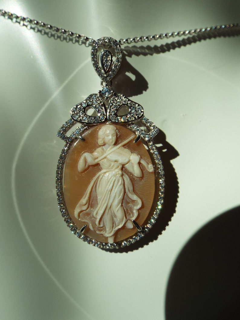 Master hand carved sardonyx cameo set into sterling silver pendant with cubic zirconia