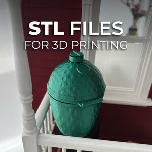 May include: A teal-colored, 3D-printed grill with a textured surface. The grill has a rounded shape with a lid and vent. The text "STL FILES FOR 3D PRINTING" is displayed in white.
