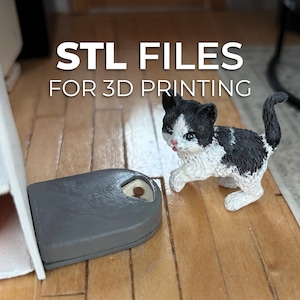 Puede incluir: Una figura en miniatura de un gatito blanco y negro junto a una maqueta de balanza gris. El texto "STL FILES FOR 3D PRINTING" se muestra en letras blancas en la parte superior de la imagen.