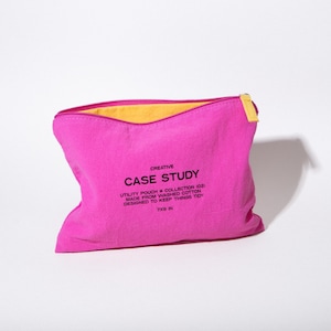 May include: A bright pink utility pouch with a yellow interior and a yellow zipper pull. The text "CASE STUDY" is printed on the front, along with details about the pouch's design and dimensions of 7x9 inches.