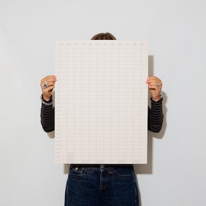 May include: A large, rectangular, off-white wall calendar featuring a grid layout. The top row lists the months from January to December, while the left column displays the numbers 1 through 31 to represent the days of each month.