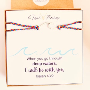 May include: A white card with a blue wave design and the text "When you go through deep waters, I will be with you. Isaiah 43:2". The card is in a brown box with a white label that says "Min's Boutique" and a website address.