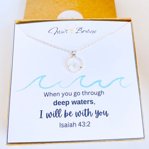 May include: A silver necklace with a wave charm and a card that reads "When you go through deep waters, I will be with you. Isaiah 43:2"