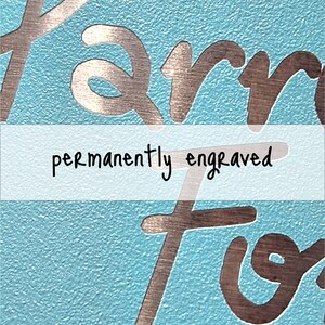 Puede incluir: Primer plano de una superficie azul con las palabras "permanently engraved" en blanco. Las palabras "Farm" y "For" est&aacute;n grabadas en plata en la superficie.