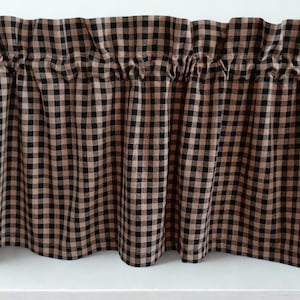 May include: A brown and black checkered valance. The fabric is gathered at the top, creating soft folds. The pattern is a classic gingham design, with evenly spaced squares. The valance is likely for a kitchen or other window.