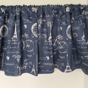 May include: A navy blue valance with a white print of bicycles, the Eiffel Tower, and Parisian-themed text. The valance has a gathered ruffle at the top.