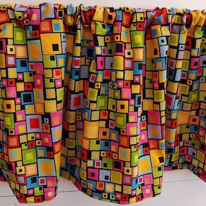 May include: A colorful fabric valance with a geometric pattern of squares in various colors, including yellow, red, blue, green, pink, and black. The squares are arranged in a random pattern on a black background.
