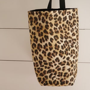 May include: A brown and tan leopard print tote bag with black handles.