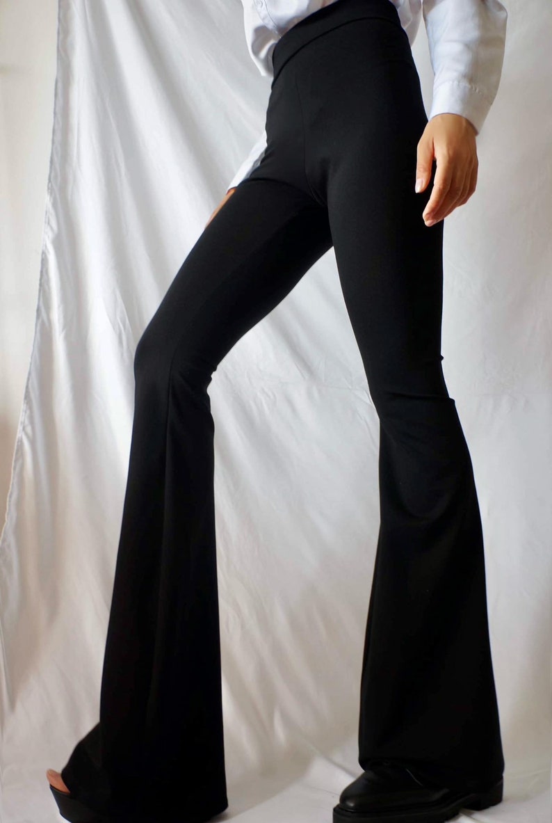 Puede incluir: Pantal&oacute;n negro acampanado de cintura alta. El pantal&oacute;n est&aacute; hecho de una tela el&aacute;stica y tiene una pierna ancha.
