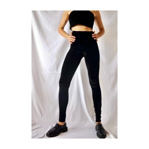Peut inclure: Leggings en velours noir à taille haute et coupe ajustée. Les leggings sont faits d'un tissu doux et extensible, parfaits pour un look décontracté ou habillé.