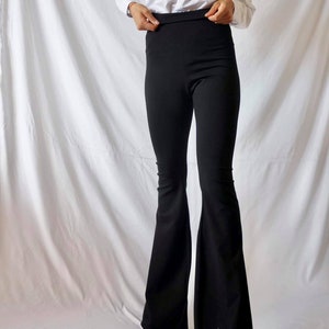 Puede incluir: Pantal&oacute;n negro de tiro alto acampanado.
