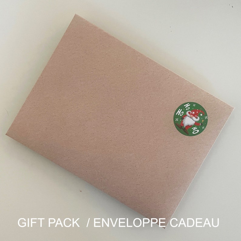 May include: A brown paper gift envelope with a round green sticker featuring a cartoon gnome with a red hat and the words "Ho Ho Ho" in white.