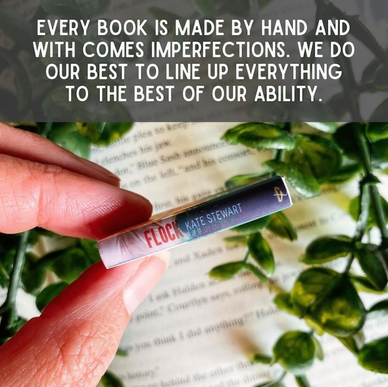 May include: A miniature book spine titled Flock by Kate Stewart with a purple and white gradient cover. The text reads: EVERY BOOK IS MADE BY HAND AND WITH COMES IMPERFECTIONS. WE DO OUR BEST TO LINE UP EVERYTHING TO THE BEST OF OUR ABILITY.
