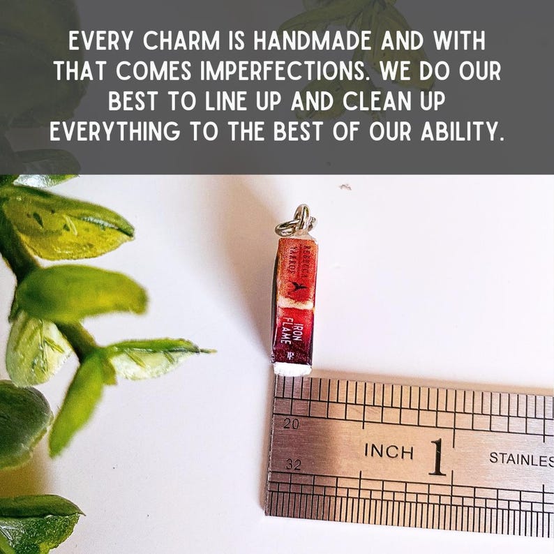 May include: A miniature book charm featuring a red spine with the text Iron Flame by Rebecca Yarros, positioned next to a stainless steel ruler showing a height of approximately 0.75 inches. The text states every charm is handmade.