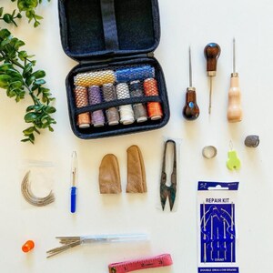 May include: A beginner's leather sewing kit containing 55 tools. The kit comes in a black carrying case and includes needles, thread, thimbles, awls, a ruler, and more.