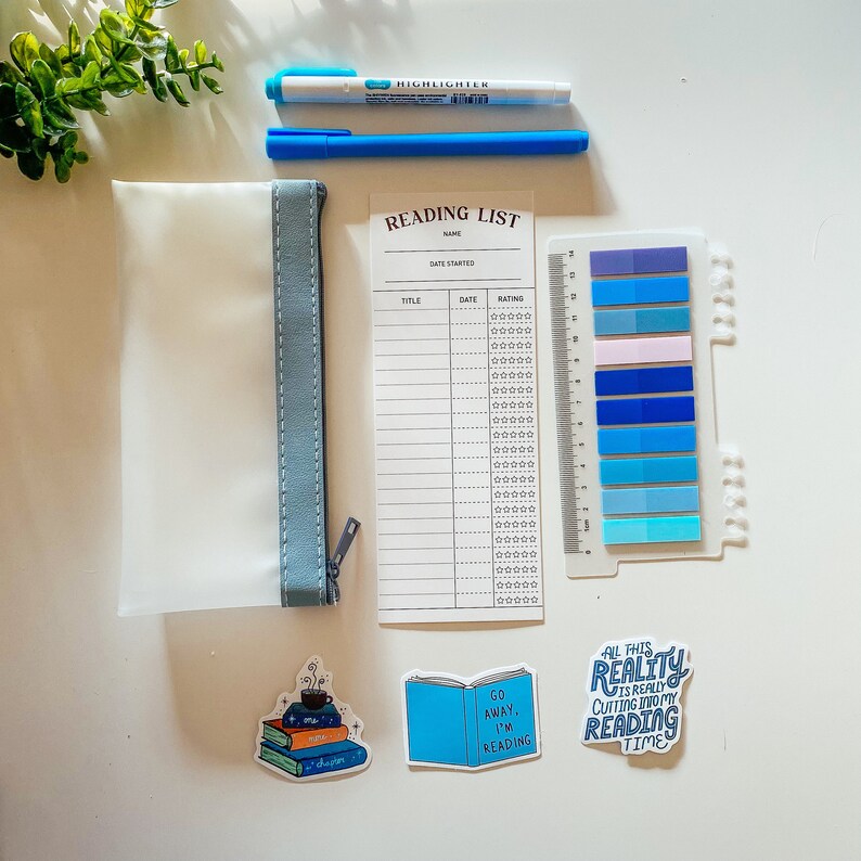 May include: A reading list printable with a blue and white color scheme. The printable has a section for title, date, and rating. There are also blue and white stickers with the text "Go Away, I'm Reading", "All This Reality Is Really Cutting Into My Reading Time", and a stack of books with a cup of coffee on top.
