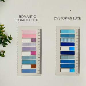 May include: Two sets of colorful patterned sticky notes, each set labeled with a theme. The set on the left is labeled "Romantic Comedy Luxe" and features pink, purple, white, and blue notes with glitter and checkered patterns. The set on the right is labeled "Dystopian Luxe" and features blue notes with checkered, glitter, and solid patterns.