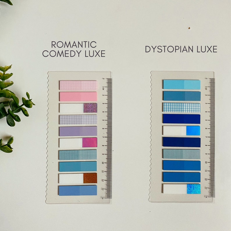 May include: Two sets of colorful patterned sticky notes, each set labeled with a theme. The set on the left is labeled "Romantic Comedy Luxe" and features pink, purple, white, and blue notes with glitter and checkered patterns. The set on the right is labeled "Dystopian Luxe" and features blue notes with checkered, glitter, and solid patterns.