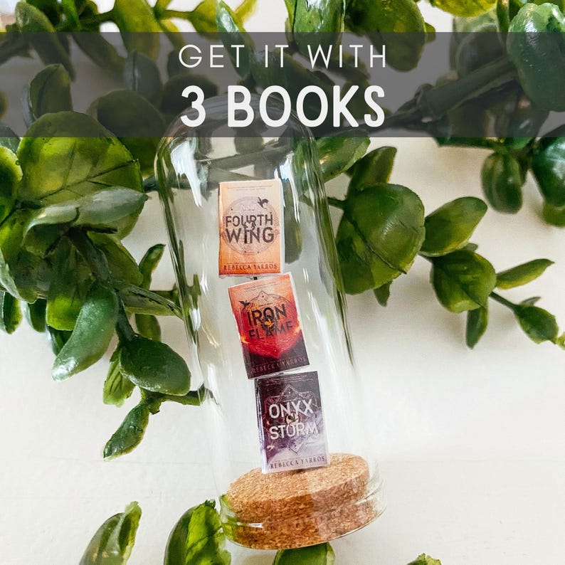 May include: A glass bottle with a cork stopper contains three miniature books. The books are titled "Fourth Wing", "Iron Flame", and "Onyx Storm". The text "Get it with 3 books" is displayed above the bottle.