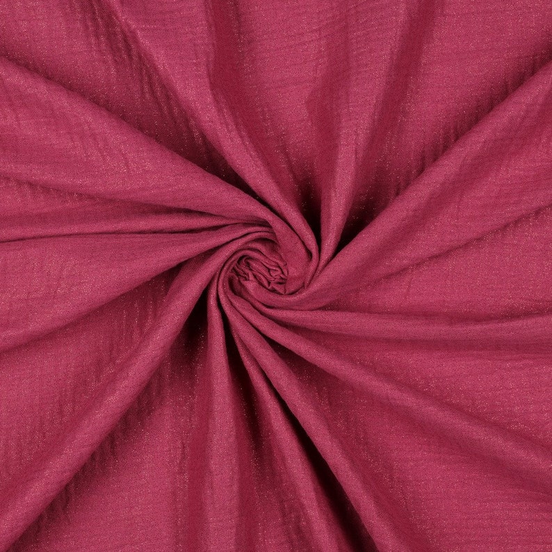 May include: A close-up of a deep pink fabric with a subtle shimmer. The fabric is soft and crinkled, creating a textured look.