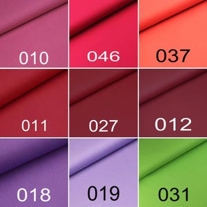 Puede incluir: Una cuadr&iacute;cula de nueve muestras de tela en varios colores, cada una etiquetada con un n&uacute;mero. Los colores incluyen tonos de rosa, rojo, coral, burdeos, morado, lavanda y verde lima. Cada muestra presenta un pliegue diagonal en la superficie.